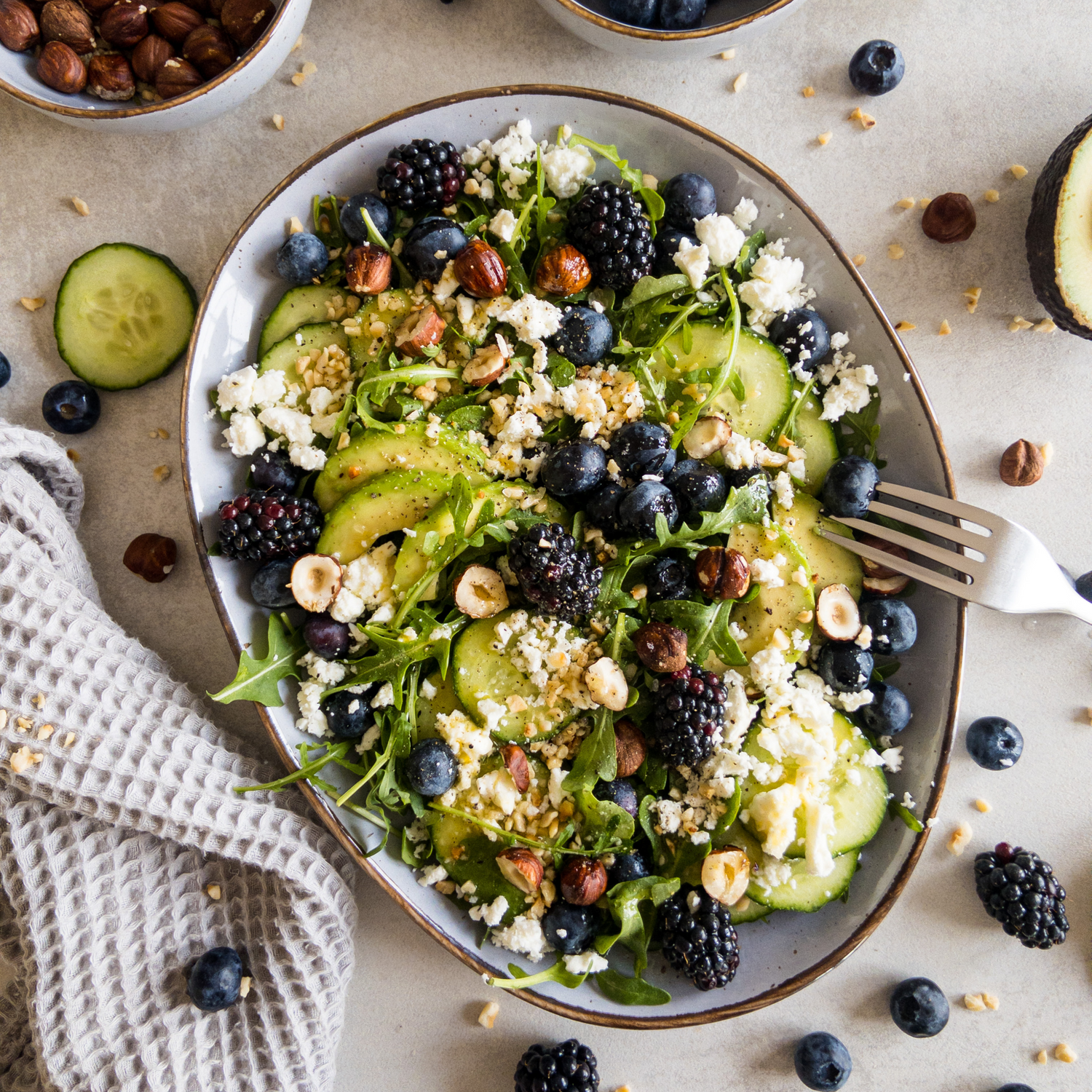 Leichter Avocado-Rucola Salat mit Beeren auf einem Teller - ideal für den Sommer.