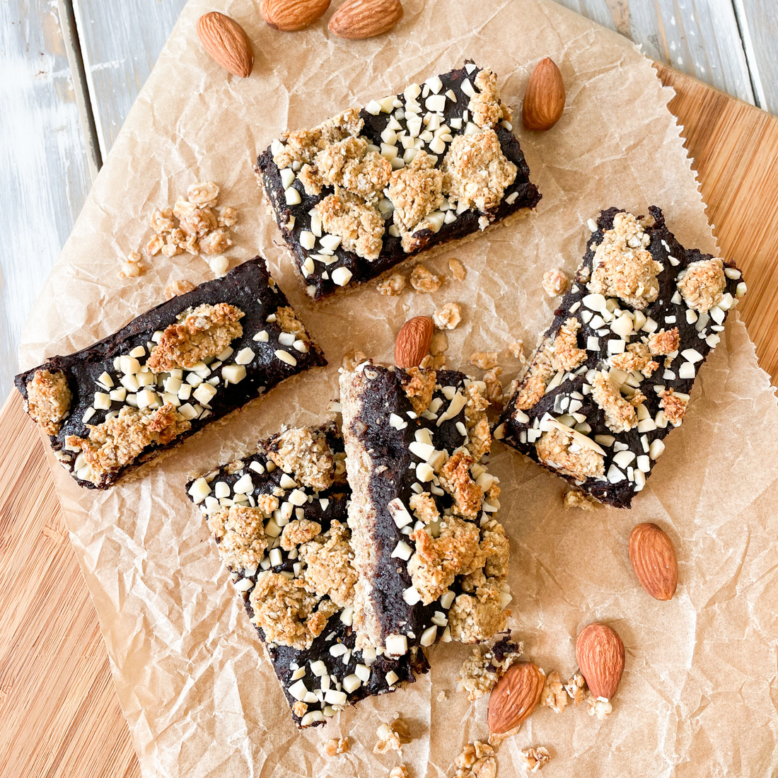 Schoko-Nuss Energy Bars auf einem Holzbrettchen, das mit Nüssen dekoriert ist.