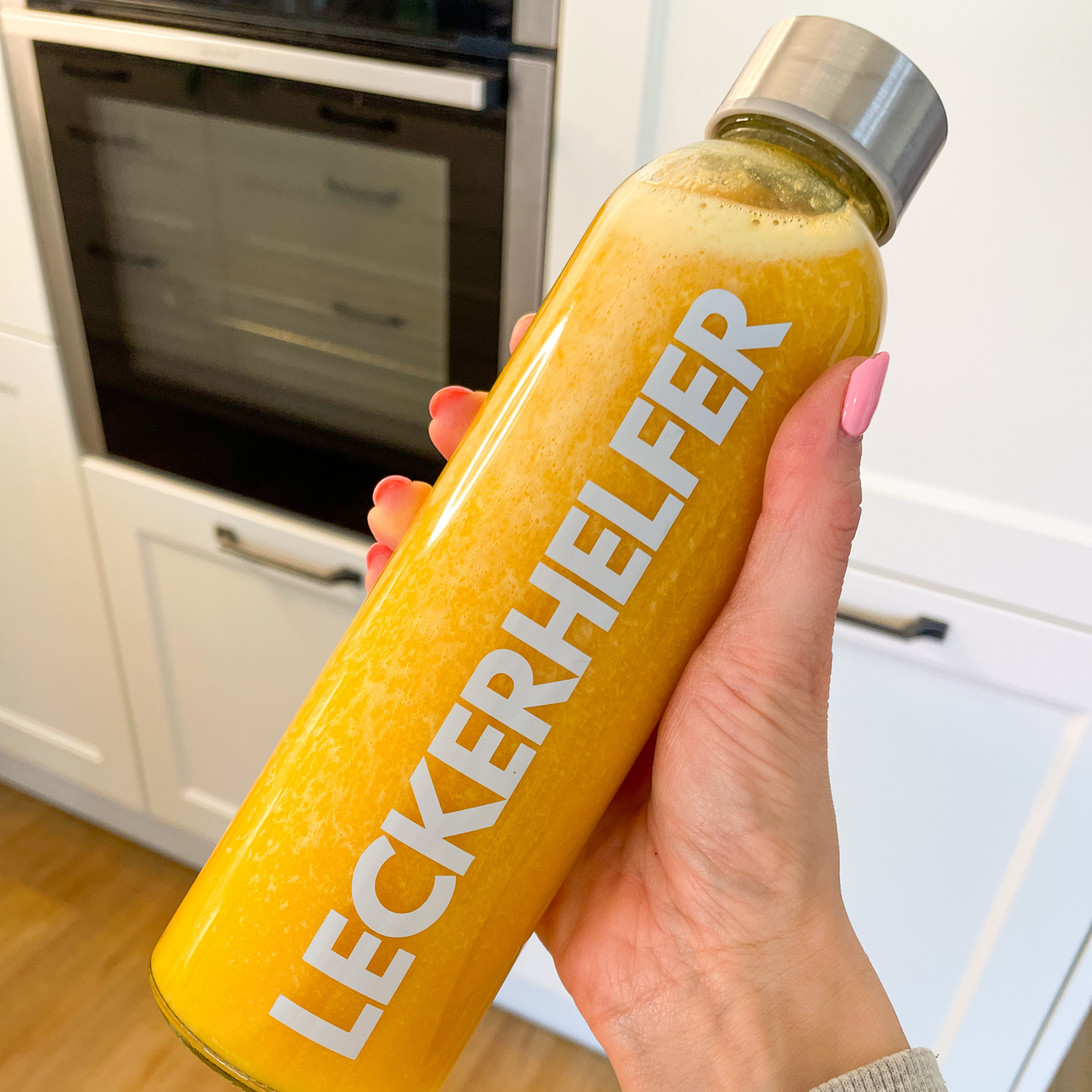 Mango Maracuja Saft in Flasche, Hand hält Flasche