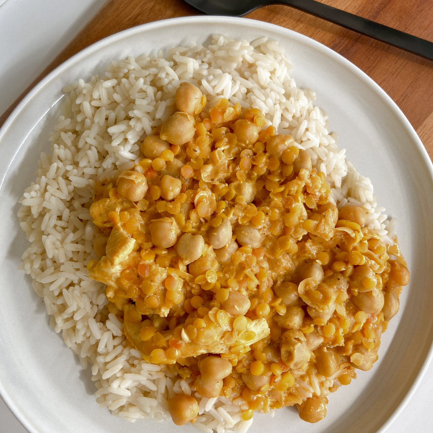 Reis mit Kokos-Linsen-Curry angerichtet auf einem Teller.